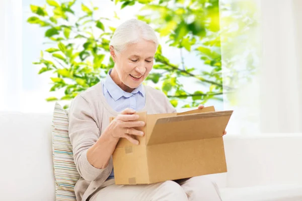 Mujer mayor feliz con caja de paquete en casa —  Fotos de Stock