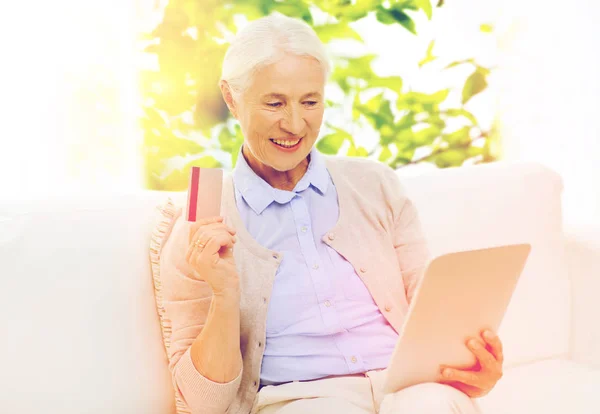 Senior vrouw met tablet pc en creditcard — Stockfoto