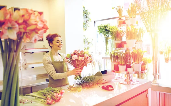 Sonriente florista mujer haciendo ramo en floristería — Foto de Stock