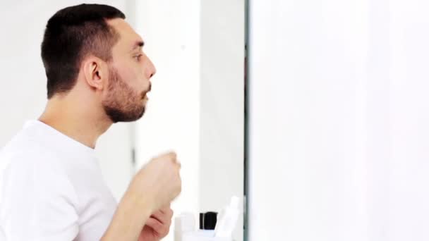 Hombre feliz cepillado pelo con peine en el baño — Vídeo de stock