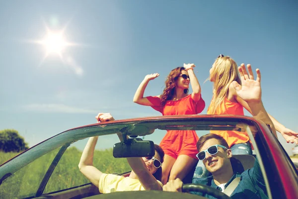 Amigos felices conduciendo en coche cabriolet — Foto de Stock