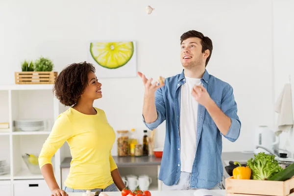 Pár vaření potravin a žonglování doma česnek — Stock fotografie