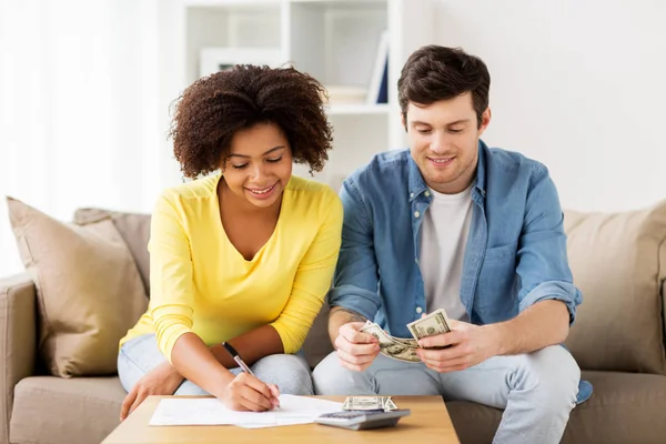 Couple heureux avec papiers et calculatrice à la maison — Photo