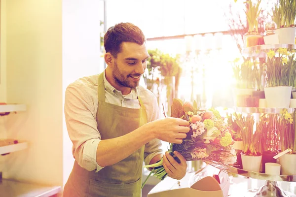 Lächelnder Blumenhändler macht Strauß im Blumenladen — Stockfoto