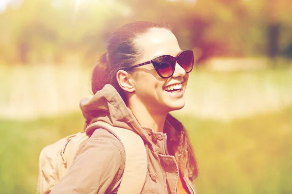 Šťastná mladá žena s batohem pěší venku — Stock fotografie