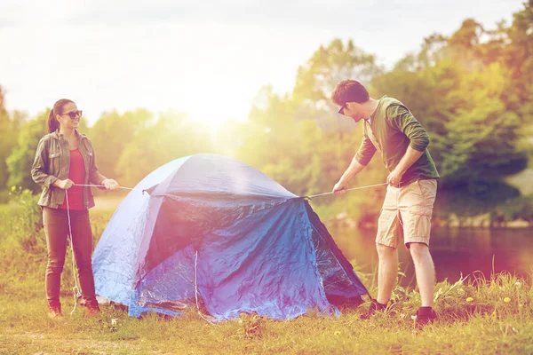 Casal feliz criação de tenda ao ar livre — Fotografia de Stock
