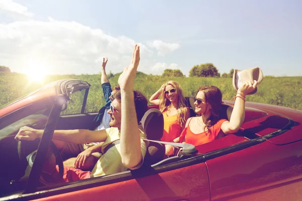 Happy přátelé jízdy v autě kabriolet na zemi — Stock fotografie