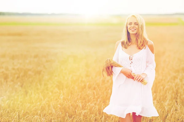 Felice giovane donna con spighette sul campo di cereali — Foto Stock