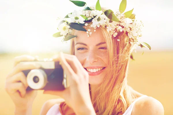 Счастливая женщина с кинокамерой в венке из цветов — стоковое фото