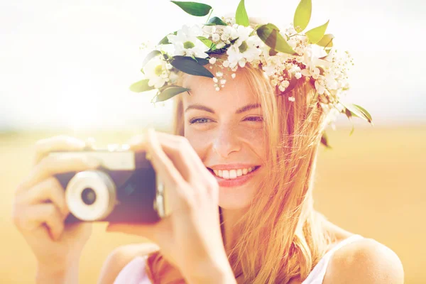 Femme heureuse avec caméra de film en couronne de fleurs — Photo