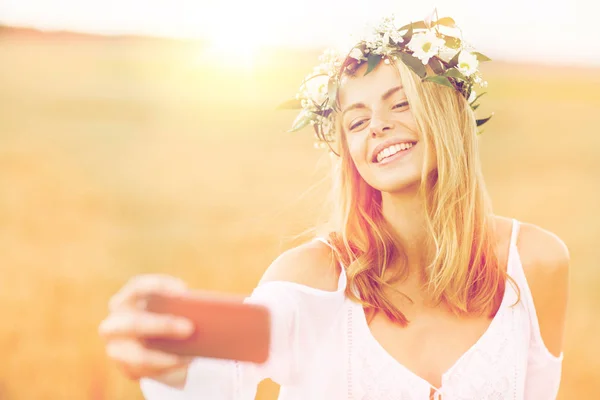 Mutlu genç bir kadın akıllı telefondan selfie çekiyor. — Stok fotoğraf