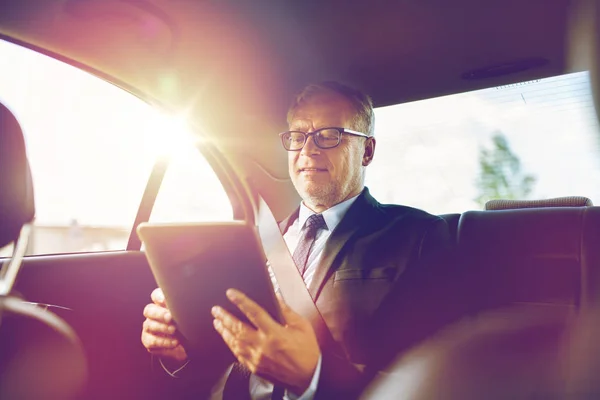 Ανώτερος επιχειρηματίας με tablet PC οδήγηση στο αυτοκίνητο Royalty Free Φωτογραφίες Αρχείου