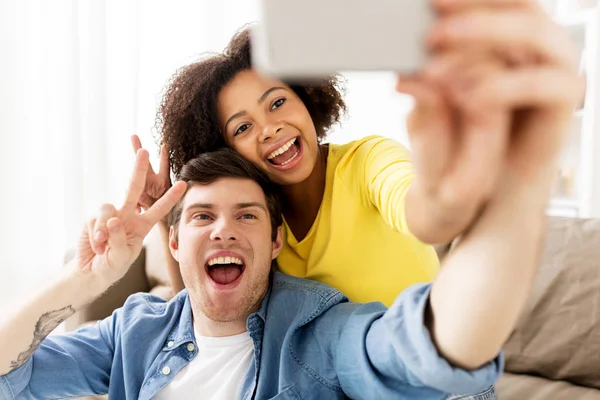 Szczęśliwa para z smartphone biorąc selfie w domu — Zdjęcie stockowe