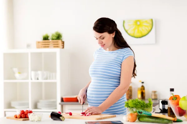 Mujer embarazada cocinar verduras en casa —  Fotos de Stock