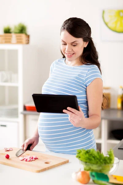 Donna incinta con tablet pc cucina a casa — Foto Stock