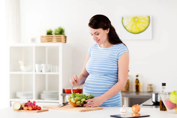 Zwangere vrouw koken groente salade thuis — Stockfoto