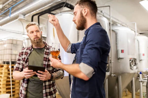 Muži s pipetou testují řemeslné pivo v pivovaru — Stock fotografie