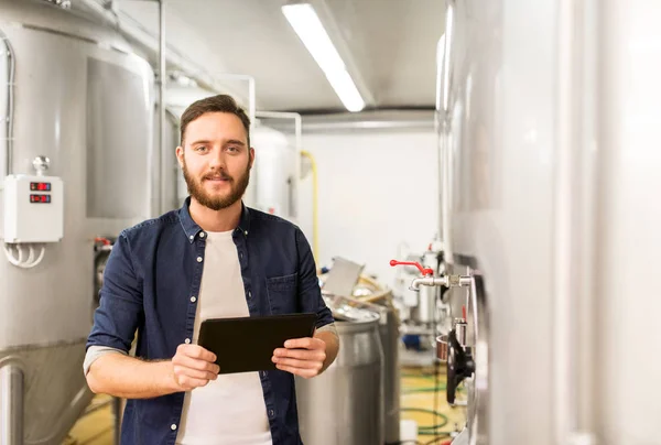 Hombre con tableta PC en la fábrica de cerveza artesanal o planta de cerveza —  Fotos de Stock