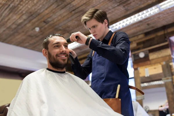 Homem e barbeiro com aparador de cabelo de corte no salão — Fotografia de Stock