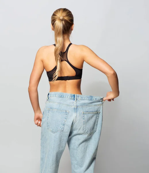 Young slim sporty woman in oversize pants — Stock Photo, Image