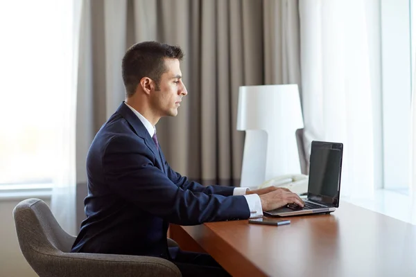 Businessman typing on laptop at hotel room Royalty Free Stock Photos