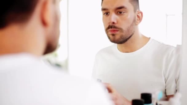 Man scheerschuim toe te passen om de baard in badkamer — Stockvideo