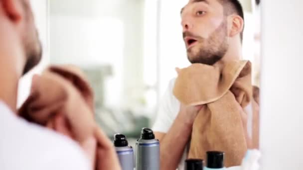 バスルームでタオルで顔を拭く男 — ストック動画