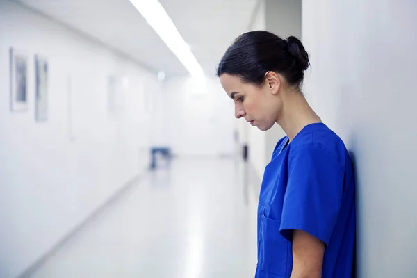 Sad female nurse at hospital corridor — Stock Photo, Image