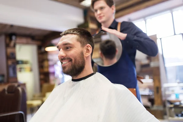 Uomo e parrucchiere con specchio dal barbiere — Foto Stock