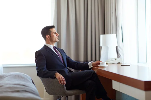 Businessman drinking coffee at hotel room — Stock Photo, Image