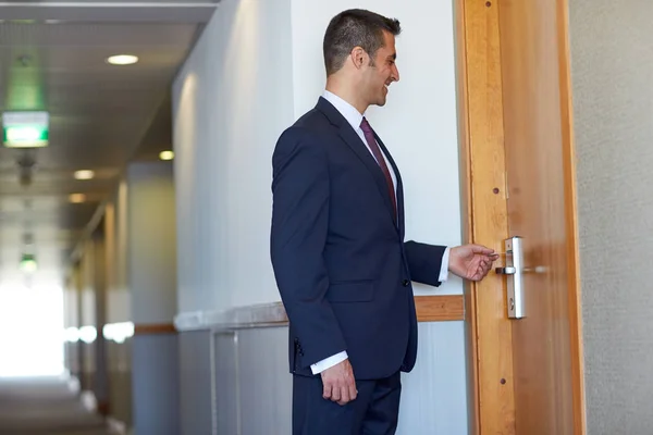 Empresário com cartão-chave na porta do hotel ou escritório — Fotografia de Stock