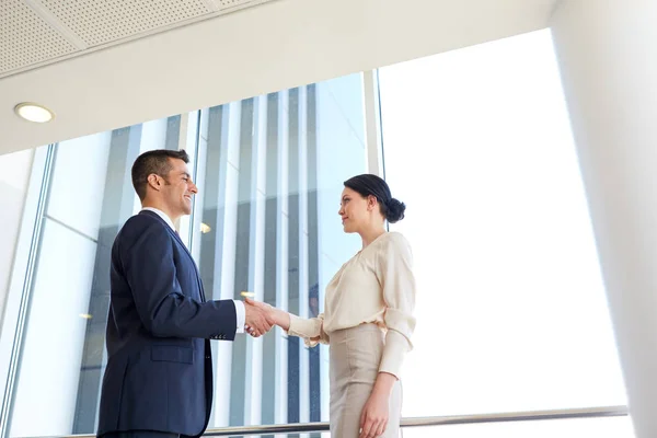 Leende affärsmän som skakar hand på kontor — Stockfoto