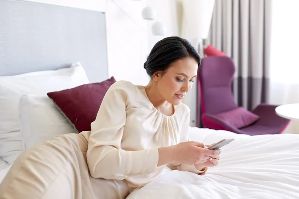 Geschäftsfrau mit Smartphone im Hotelzimmer — Stockfoto
