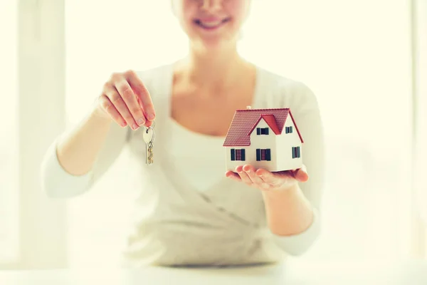 Close up de mulher segurando modelo de casa e chaves — Fotografia de Stock