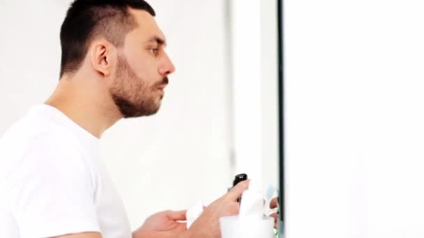 Mann trägt Rasierschaum auf Bart im Badezimmer auf — Stockvideo