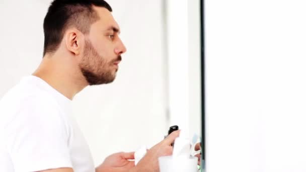 Uomo che applica schiuma da barba alla barba in bagno — Video Stock