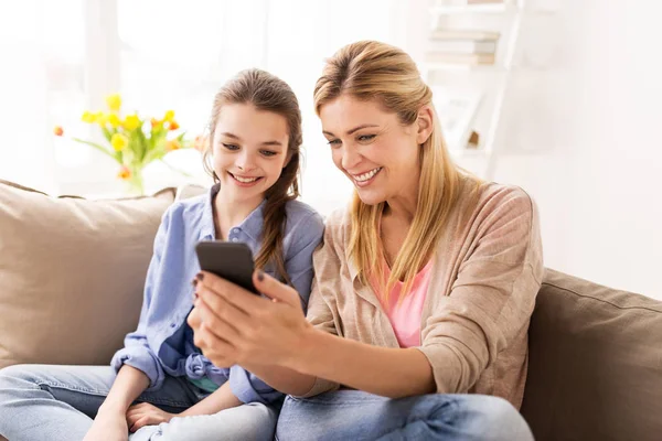 Szczęśliwa rodzina ze smartfonem w domu — Zdjęcie stockowe
