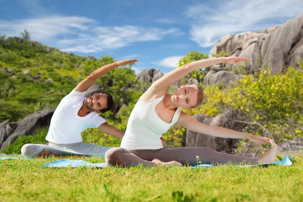 Pasangan bahagia melakukan latihan yoga di luar ruangan — Stok Foto