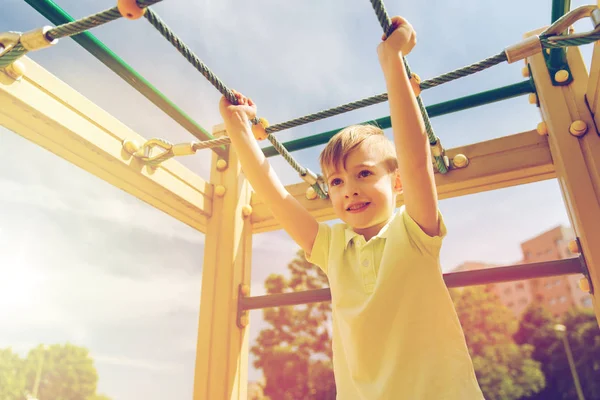 Glad liten pojke klättring på lekplats — Stockfoto