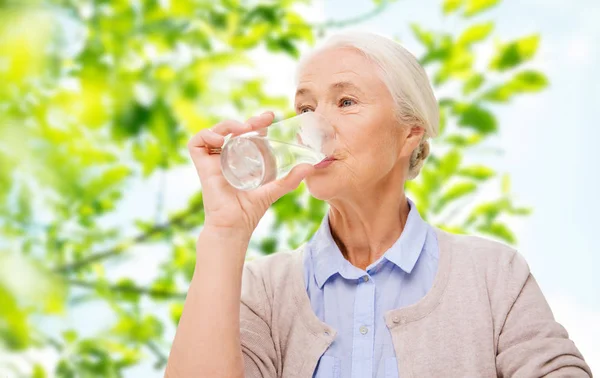 Happy senior woman with glass of water at home — Stock Photo, Image