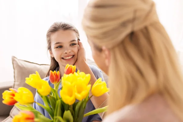 幸せな女の子は家で母親に花をあげ — ストック写真
