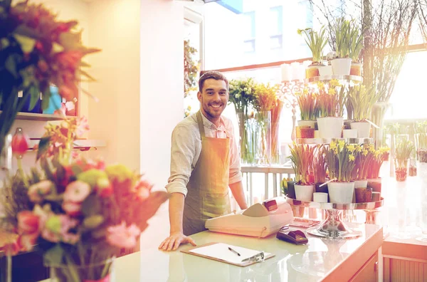 Florista hombre con portapapeles en el mostrador de la tienda de flores —  Fotos de Stock