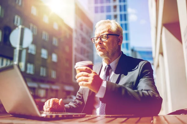 Senior businessman with laptop drinking coffee — Stock Photo, Image