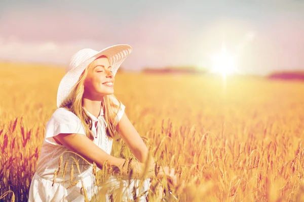 Felice giovane donna in cappello da sole sul campo di cereali — Foto Stock