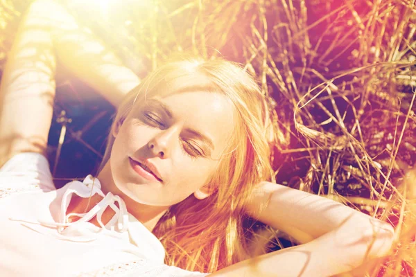 Happy young woman lying on cereal field or hay — Stock Photo, Image