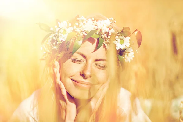 Happy woman in wreath of flowers on cereal field — Stock Photo, Image
