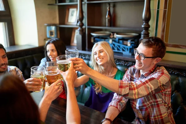 Amigos felizes bebendo cerveja no bar ou pub — Fotografia de Stock