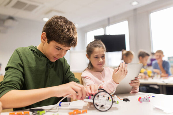 Kids with tablet pc programming at robotics school — Stock Photo, Image