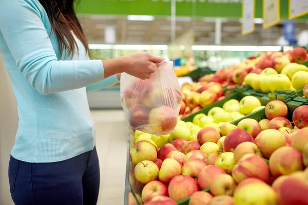 Woman with bag buying apples at grocery store — Stock Photo, Image