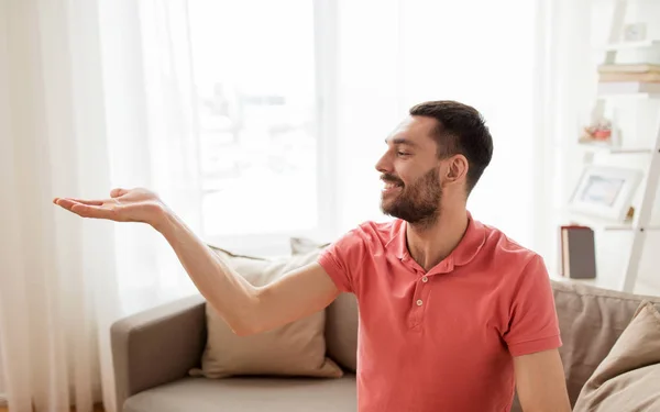 Hombre feliz sosteniendo algo imaginario en casa — Foto de Stock